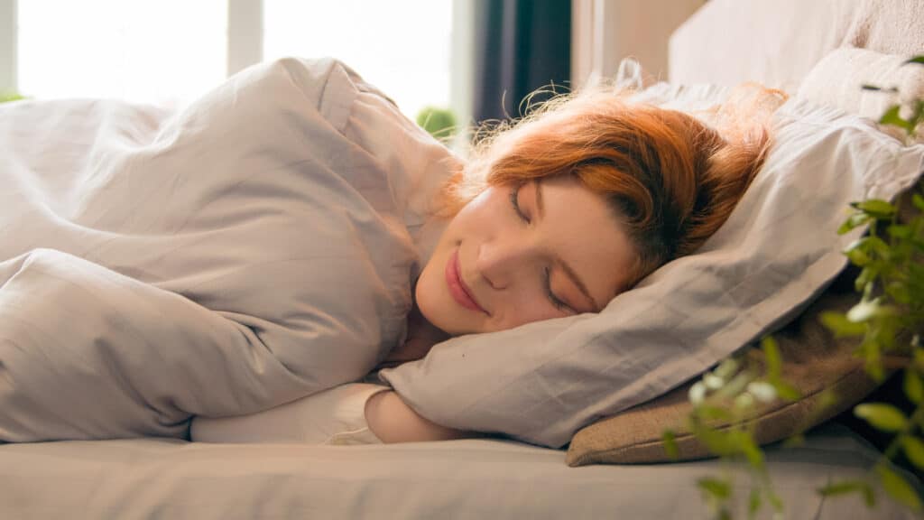 Caucasian happy woman sleeping in comfortable cozy bed at home girl lady asleep lying on soft pillow white linen orthopedic mattress resting relaxing napping healthy sleep nap in morning stress relief. High quality 4k footage