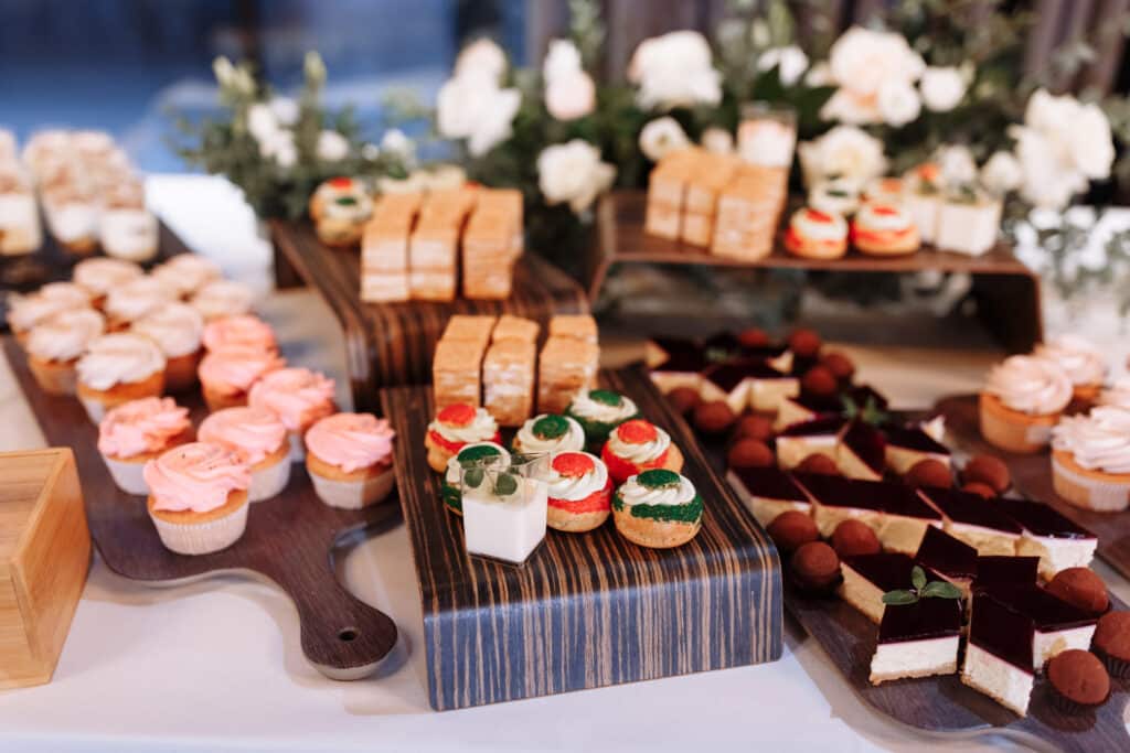 candy bar decorated by delicious sweet buffet with cupcakes, eclairs, sweetness and flowers, and other desserts, candy, Dessert table for a wedding or birthday party