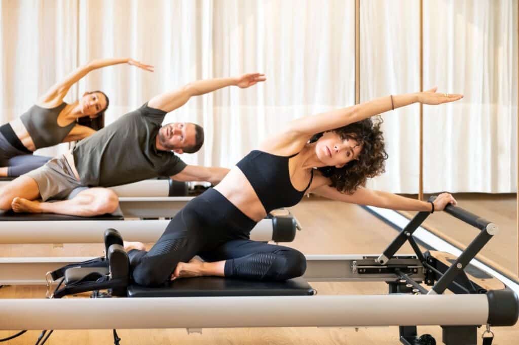 Group of people doing mermaid exercise on pilates