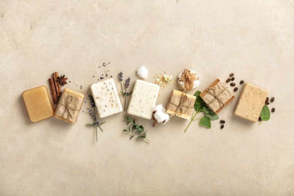 Handmade soap bars and ingredients on natural stone background