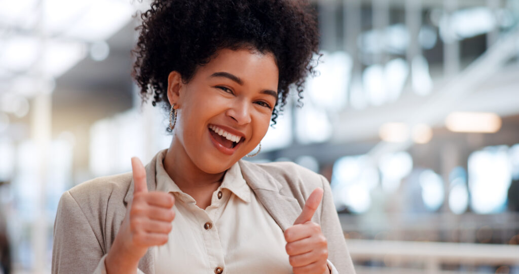 Thumbs up, business and face of black woman with emoji gesture for congratulations, job well done.